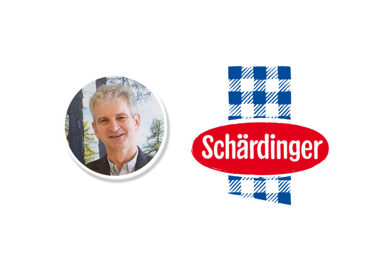 Ein Mann lächelt in die Kamera vor einem baumreichen Hintergrund. Rechts daneben das Schärdinger-Logo mit blau-weißem Karomuster und rotem Oval.