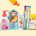 Mehrere Kinderpflegeprodukte vor einem hellen Hintergrund. Enthalten sind ein Schaumspender mit Kirschmotiv, Schaumbad mit Affendesign, Kinderzahngel, ein Zahnbürstenset und ein Glas mit Multivitaminbärchen. Bunt und kindgerecht gestaltet.