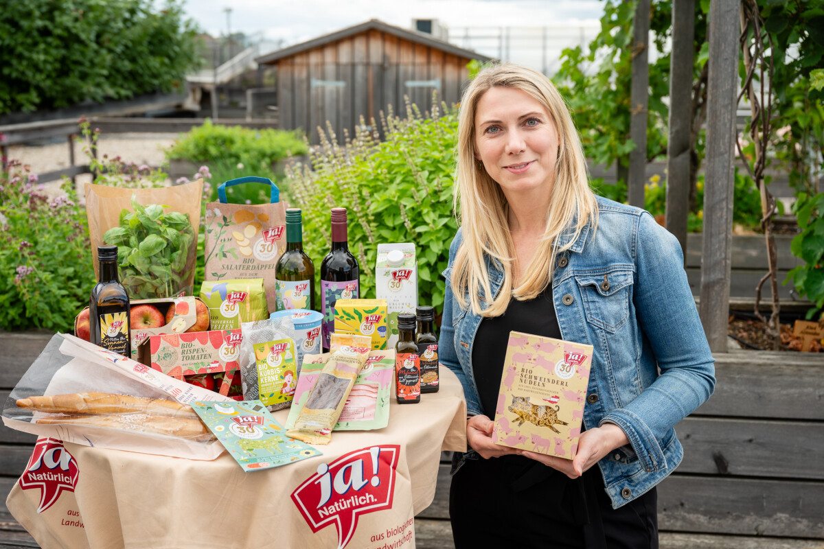 Klaudia Atzmüller (Geschäftsführerin Ja! Natürlich) mit Produkten im Jubiläumsdesign