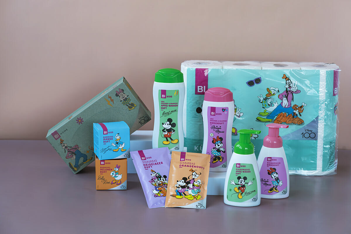 Eine Auswahl an Disney-Produkten, darunter Seifen, Shampoos, Feuchttücher und Toilettenpapier, verziert mit Disney-Figuren wie Micky Maus und Goofy. Die Verpackungen sind bunt und zeigen die verschiedenen Charaktere.