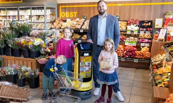 BILLA Kaufmann Marko Miskovic freut sich zusammen mit seinen kleinen Kund:innen über den Support der Roboter in seinem Markt in Gloggnitz.