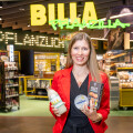 Verena Wiederkehr, BILLA Head of Plant-Based Business Development, mit dem neuen tierfreien Käse, dem preisreduzierten 3D-Lachsfilet und dem frisch gezapften Haferdrink.