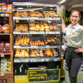 Barbara Boeschen (BILLA PFLANZILLA deputy store manager) with the new BILLA PFLANZILLA baking station, which offers the pleasure of baked, purely plant-based bacon breadsticks, pizzas and much more.