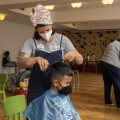 Children of homeless families who have just found a transitional home at the facility were invited to a haircut.