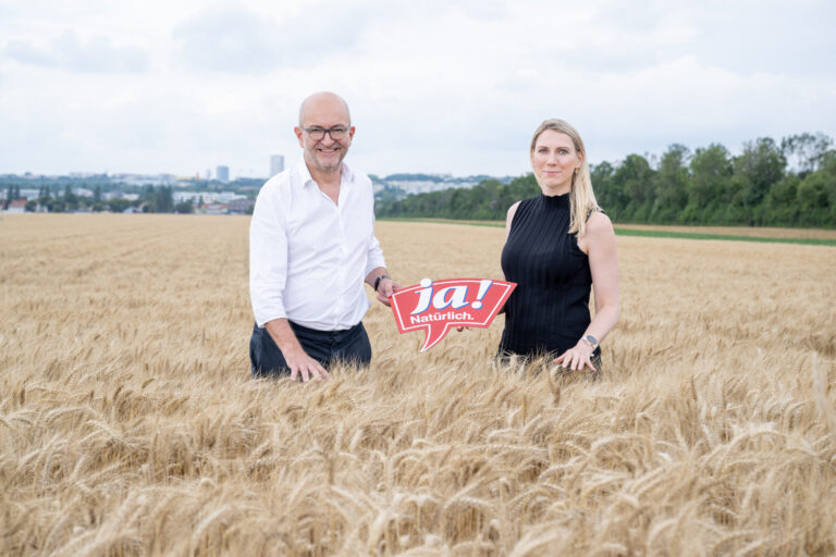 Ja! Natürlich Geschäftsführer Claudia Atzmüller & Andreas Steidl stehen in einem Weizenfeld